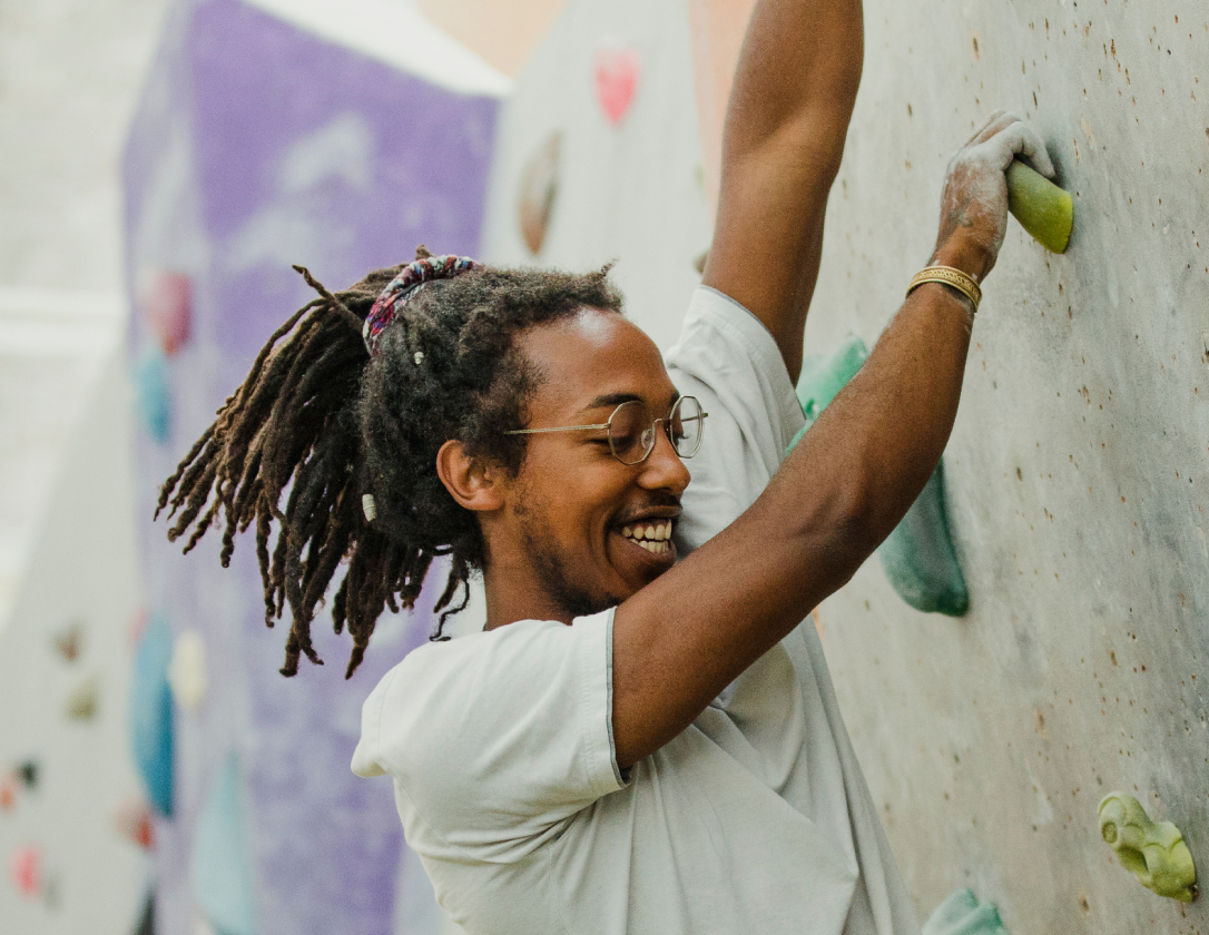 A male doing indoor rock climbing. 