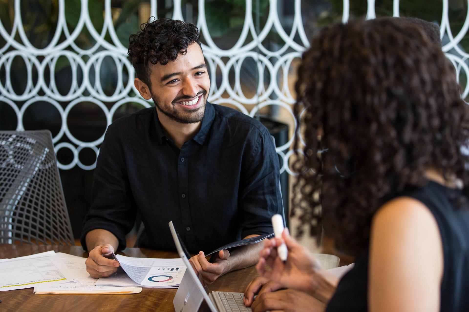 Male student talking with a colleague in a work setting. 