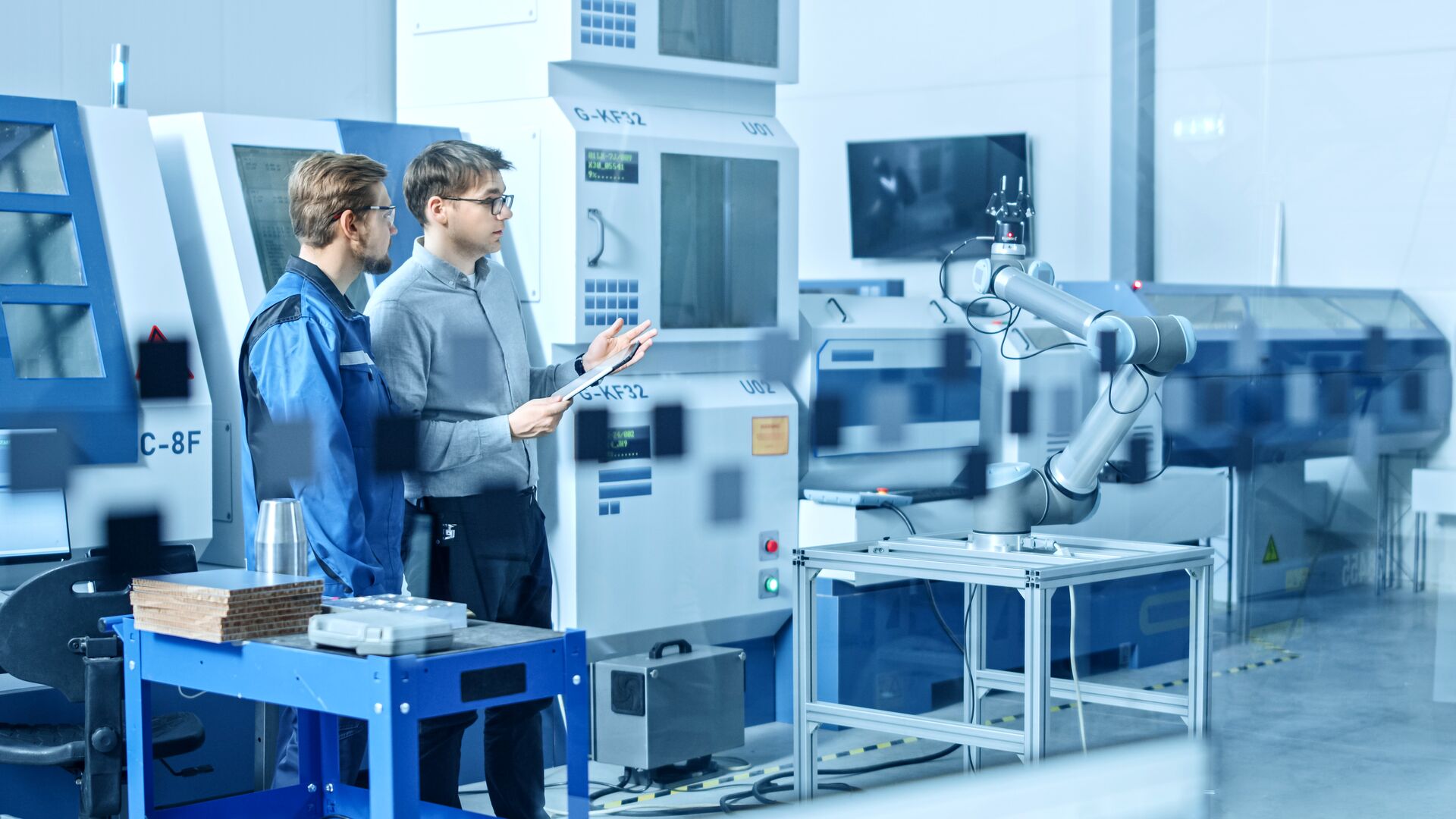 Two males standing in an advanced manufacturing facility. 